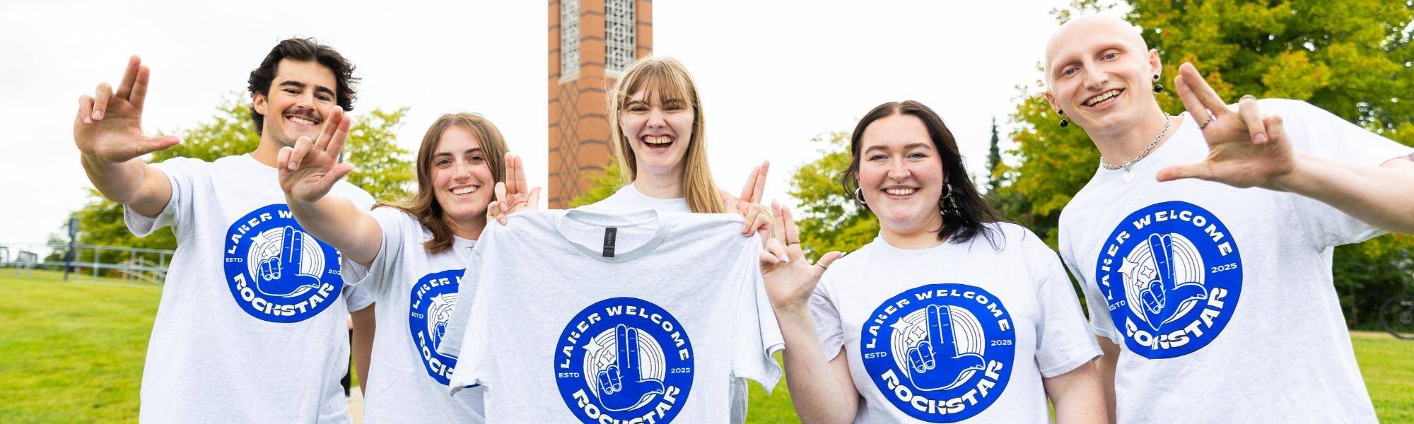 Students wearing "Laker Welcome Rockstar" t-shirts and holding up the "anchor up!" hand signal